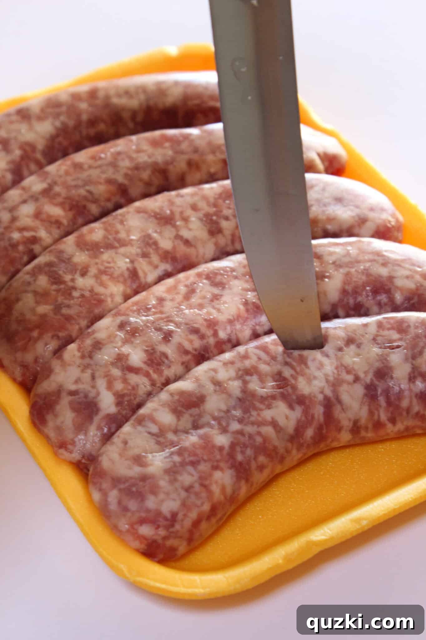 Tek Tepsi Sosisli Patates Lezzeti 3 Making cuts in the Brats to allow flavors to penetrate during pre-boiling.