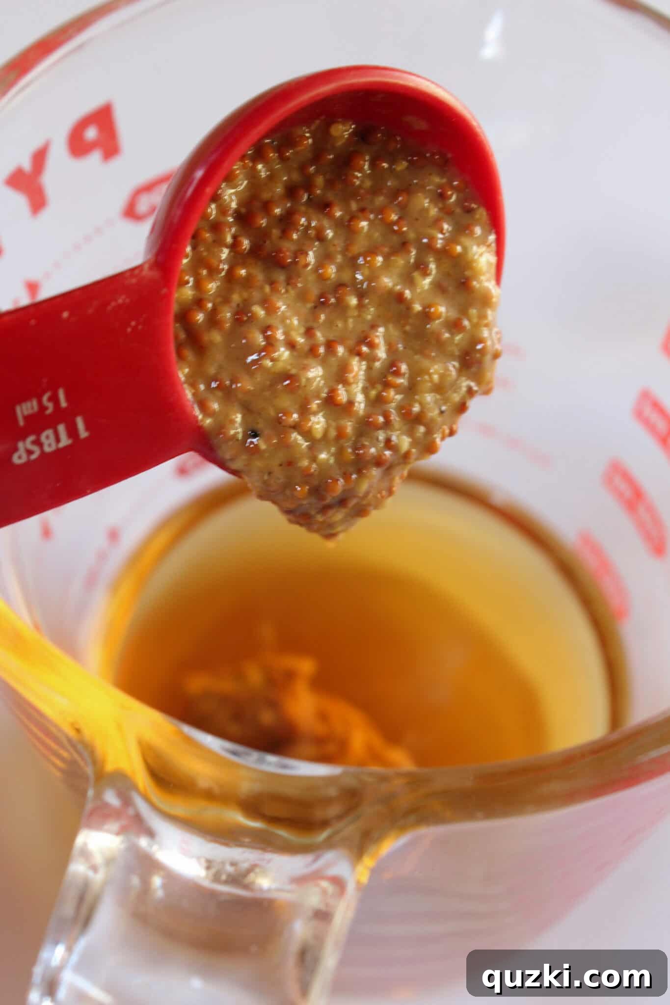 Tek Tepsi Sosisli Patates Lezzeti 6 Preparing the honey mustard sauce by whisking apple cider vinegar, various mustards, and honey.