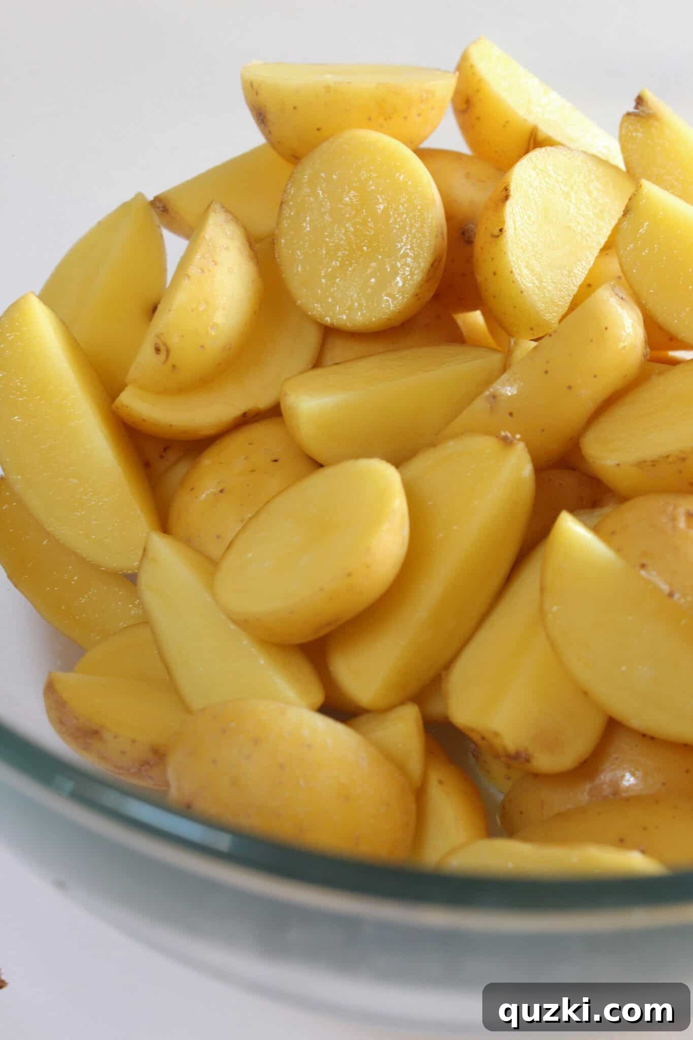 Tek Tepsi Sosisli Patates Lezzeti 7 Cutting mini Yukon Gold potatoes into halves or quarters for optimal roasting.