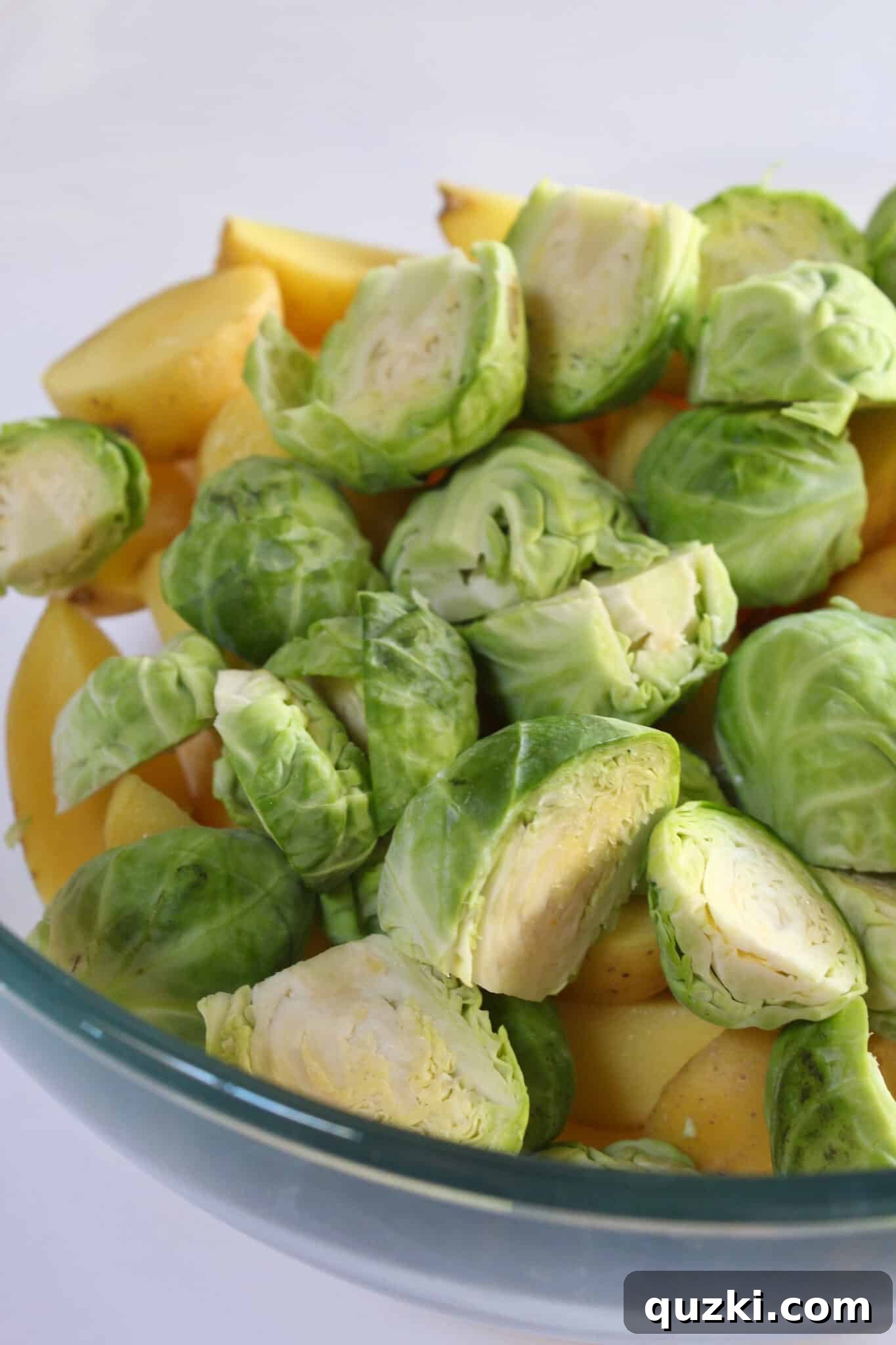 Tek Tepsi Sosisli Patates Lezzeti 8 Prepping Brussels sprouts by halving them and removing loose leaves for the sheet pan dinner.