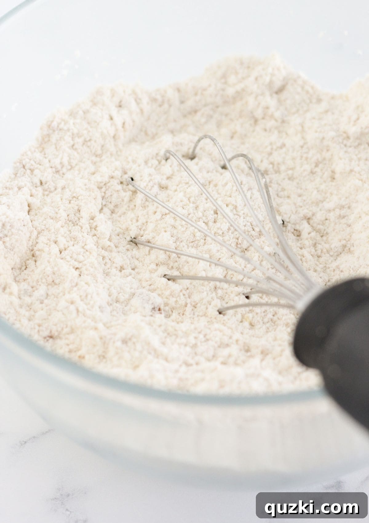 Whisking dry ingredients: yellow cake mix and brown sugar in a large mixing bowl.