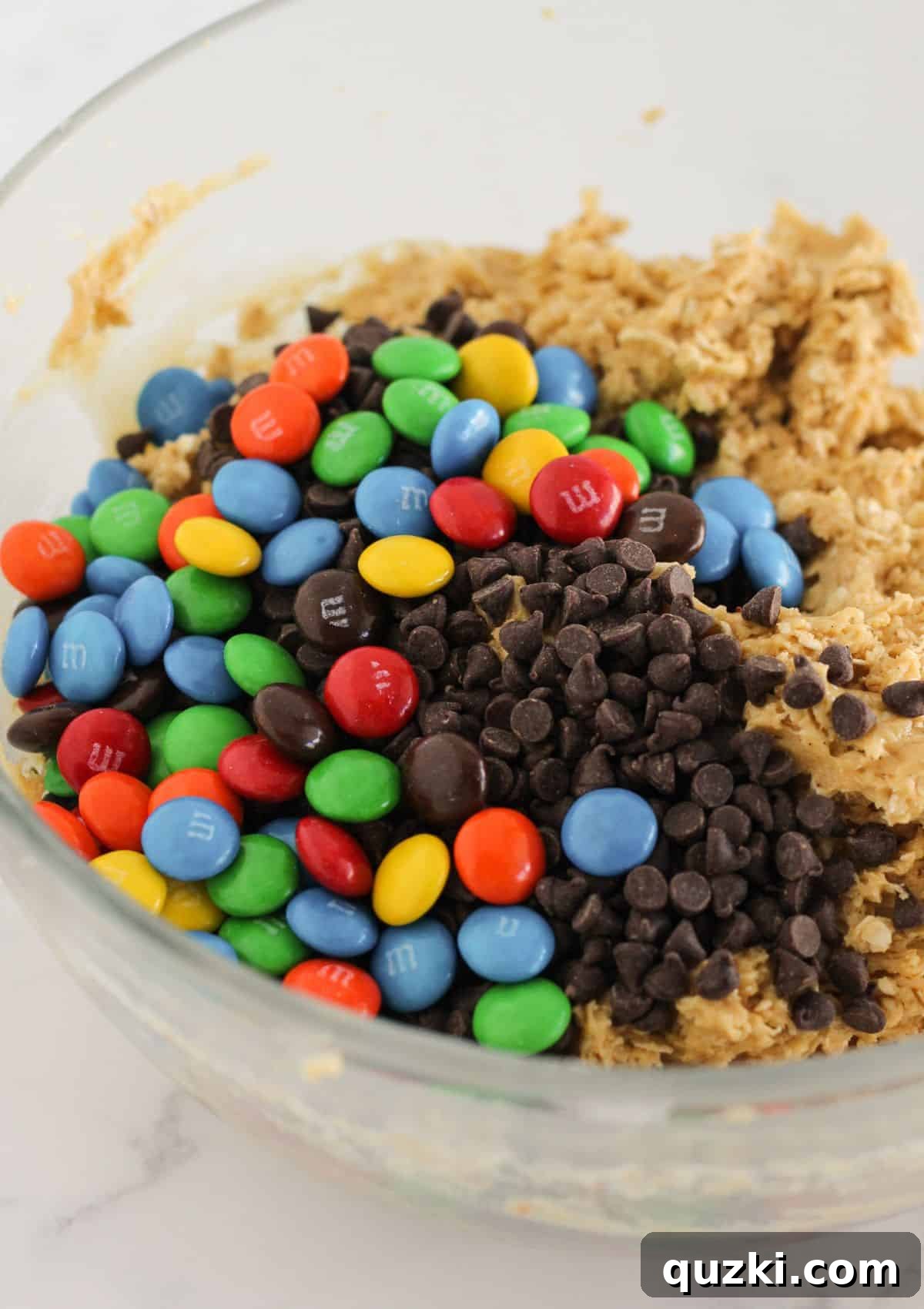 Folding mini chocolate chips and M&M's into the monster cookie dough.