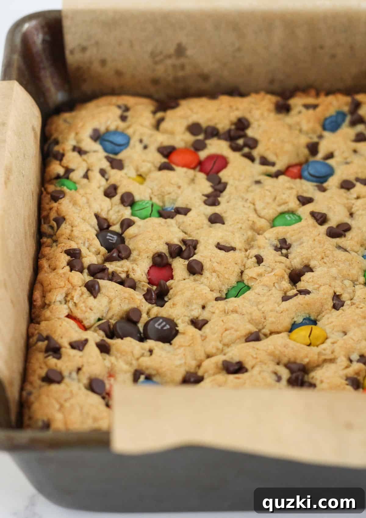 Golden brown monster cookie bars fresh out of the oven, still in the baking pan.
