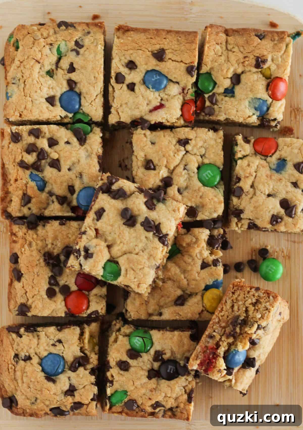 Cooled monster cookie bars sliced neatly into squares on a cutting board.