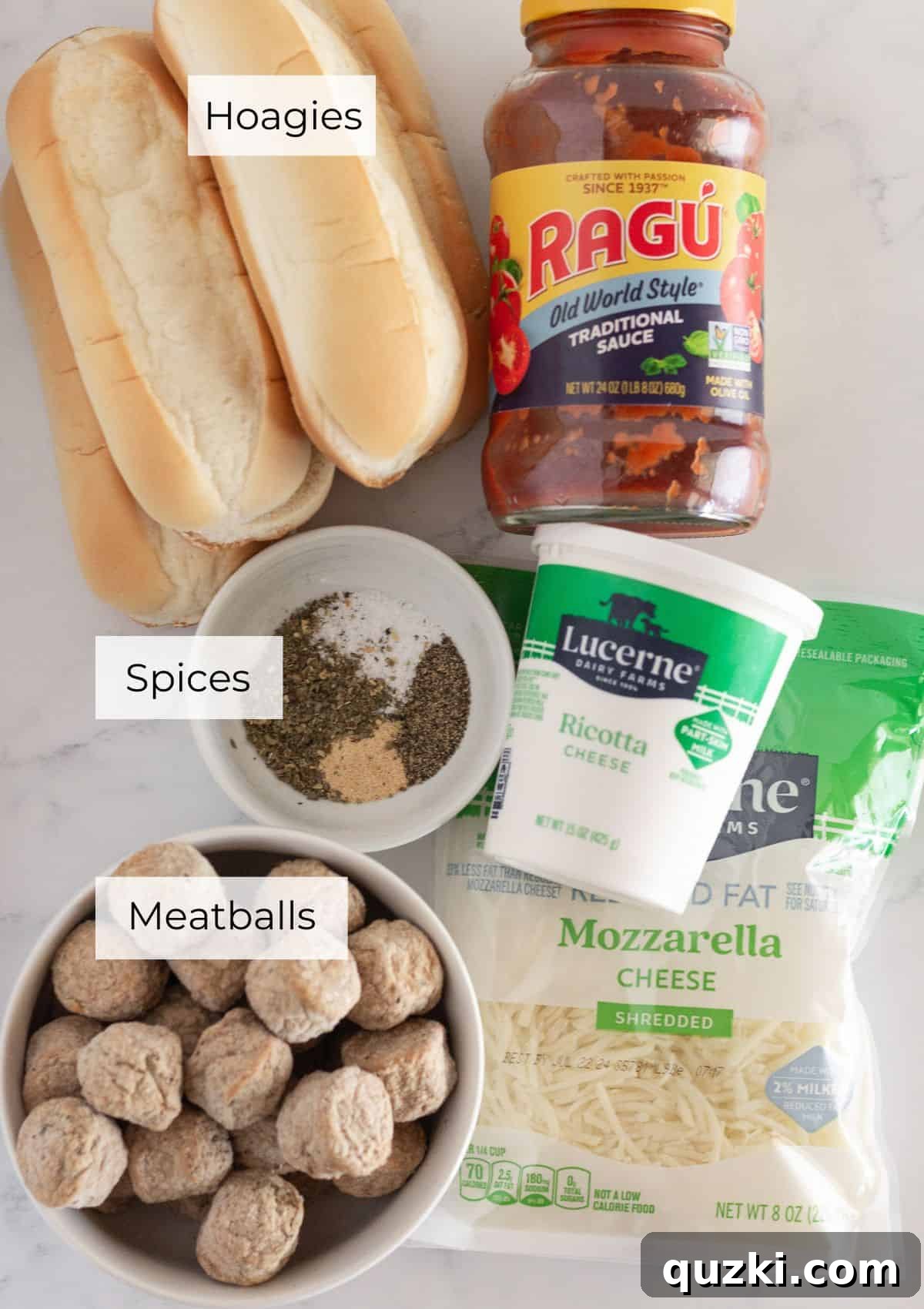 All the essential ingredients neatly arranged for making a Meatball Sub Casserole, including hoagie rolls, cheese, meatballs, and sauce.