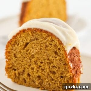 Two slices of pumpkin spice bundt cake, showcasing the beautiful frosting and moist interior.