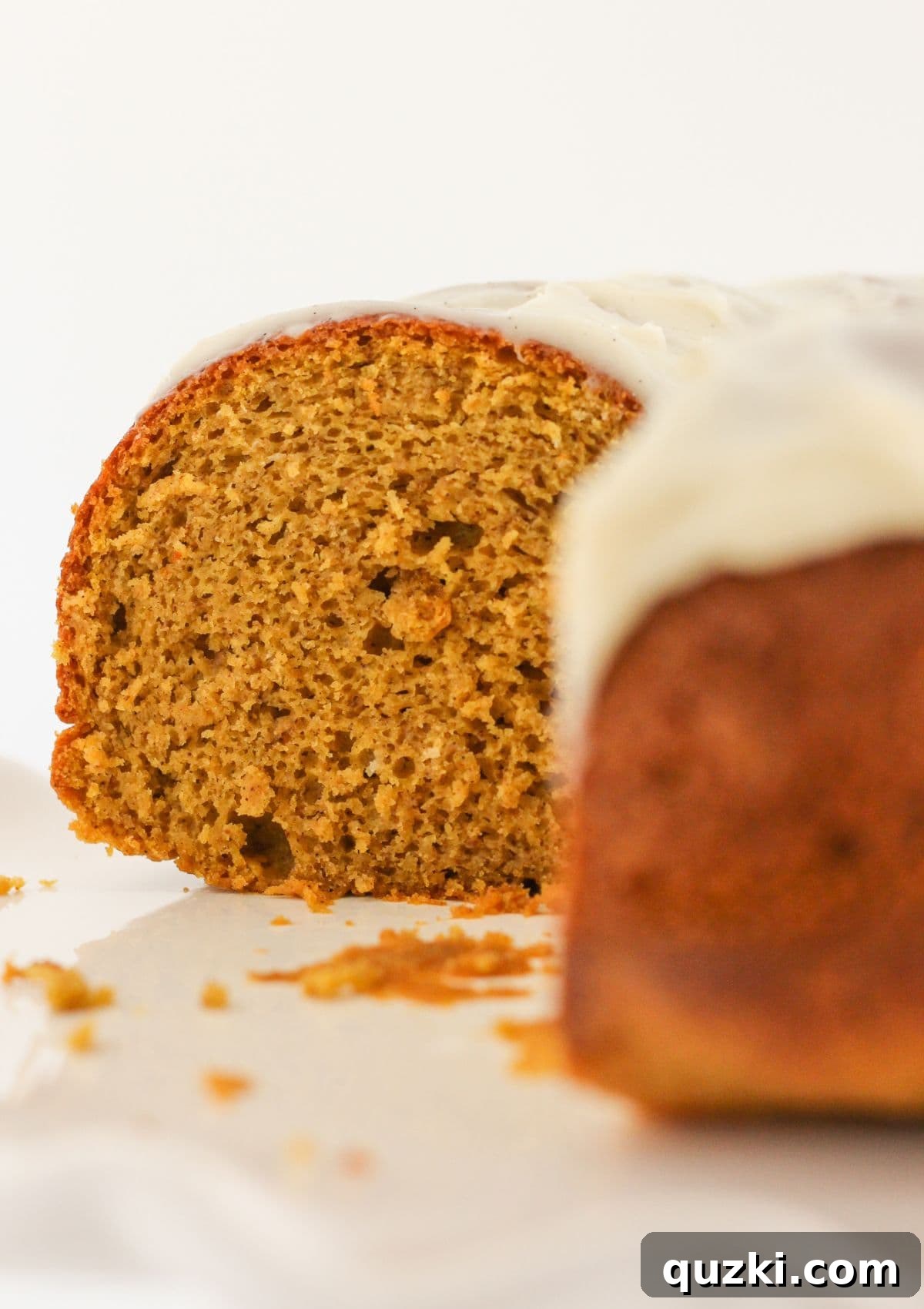 A pumpkin spice bundt cake with several slices already removed, revealing its inviting texture.