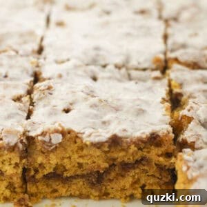 Pumpkin cinnamon roll cake perfectly cut into inviting squares, ready to be served.