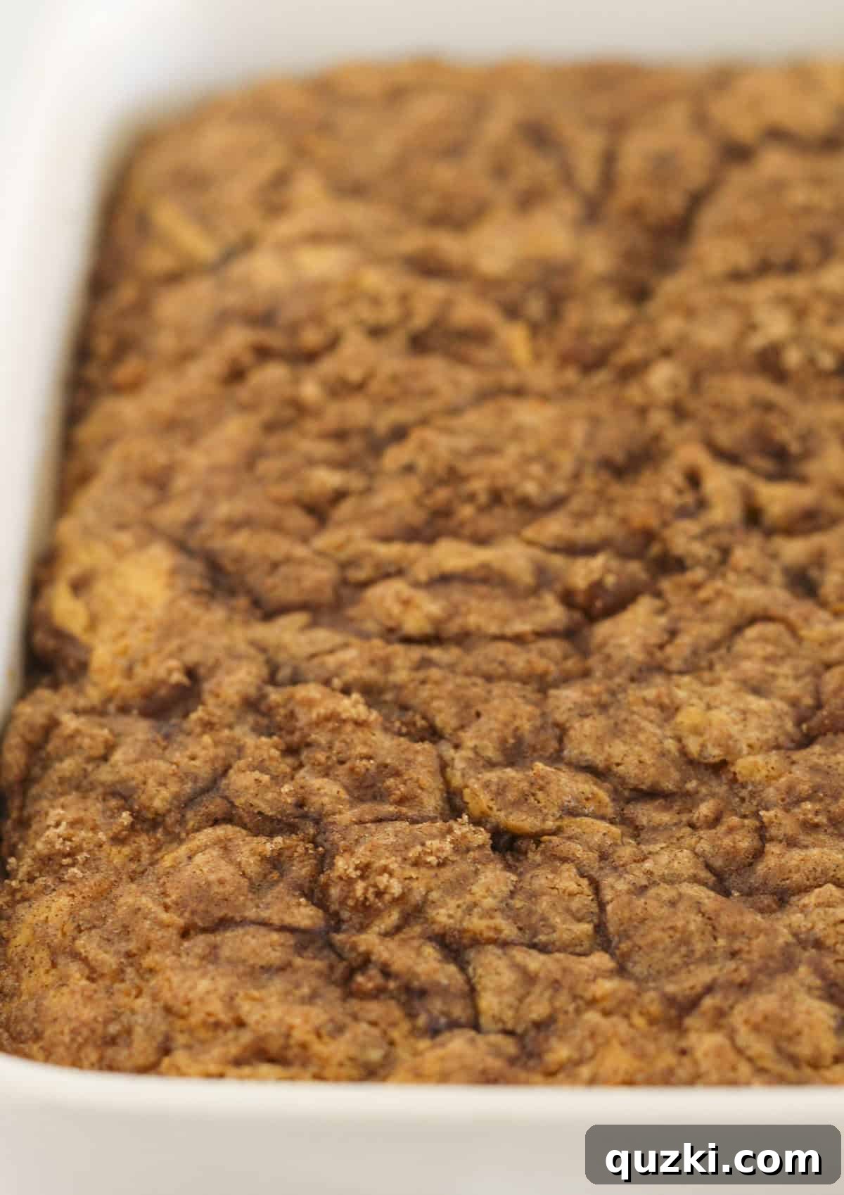 The pumpkin cinnamon roll cake baking to a golden-brown perfection in the preheated oven.