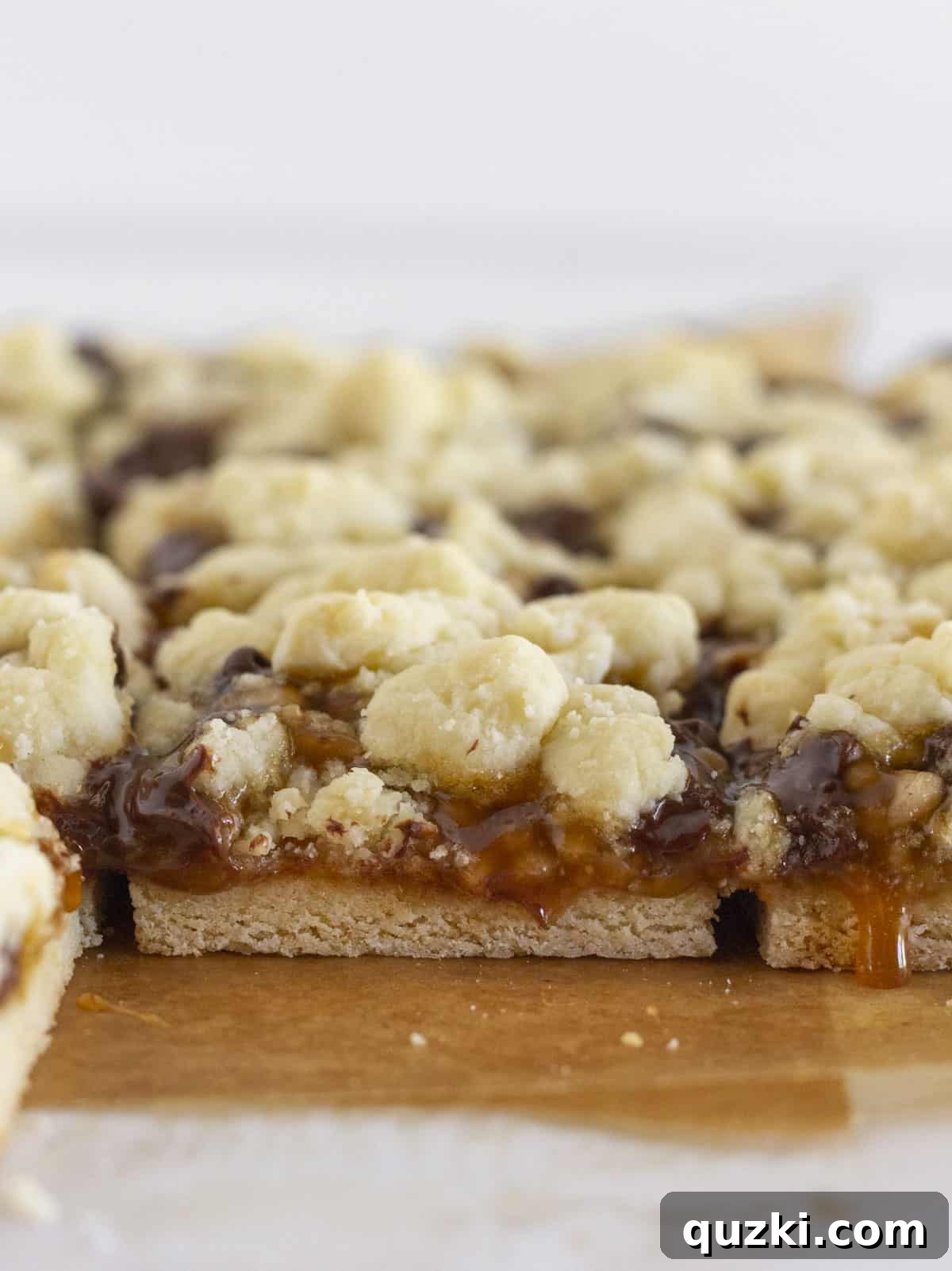 Buttery Toffee Chocolate Chip Bars 7 Perfectly cut Easy Toffee Cookie Bars arranged neatly on a white serving tray, ready to be enjoyed.
