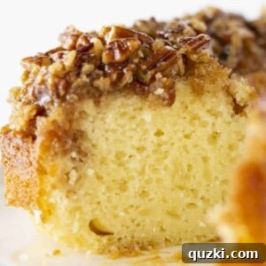 A stunning Pecan Upside Down Bundt Cake with a slice gracefully removed, revealing its moist interior and luscious topping.