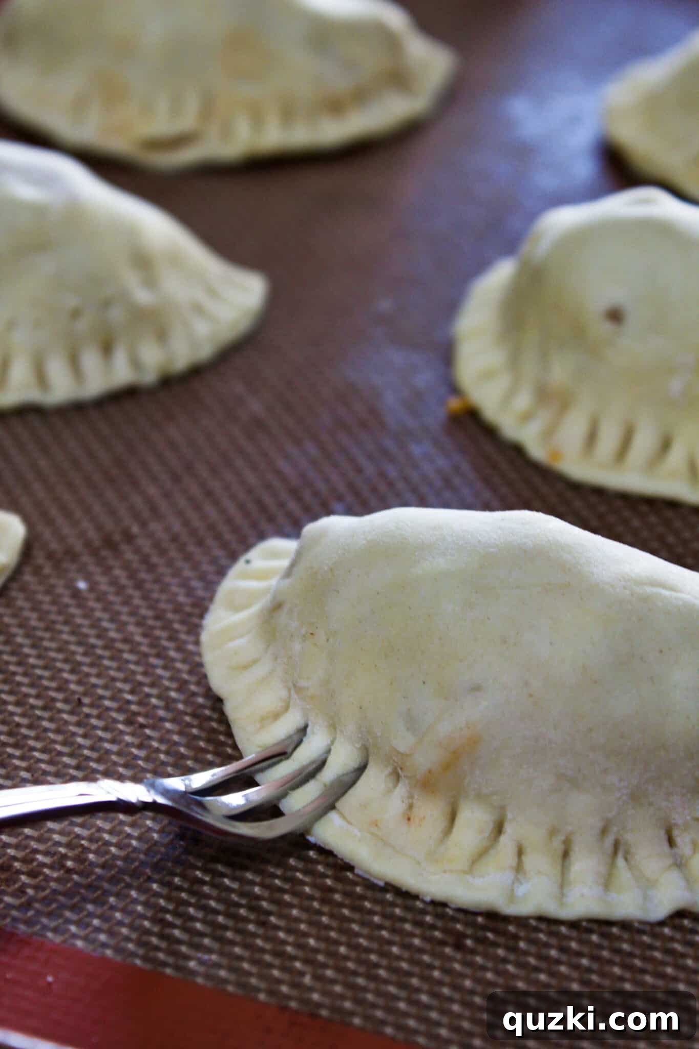 Thanksgiving Leftover Turkey Empanadas: A Delicious Reinvention 11 Puff pastry empanadas sealed with a fork, showing the crimped edges and ready for the next step.