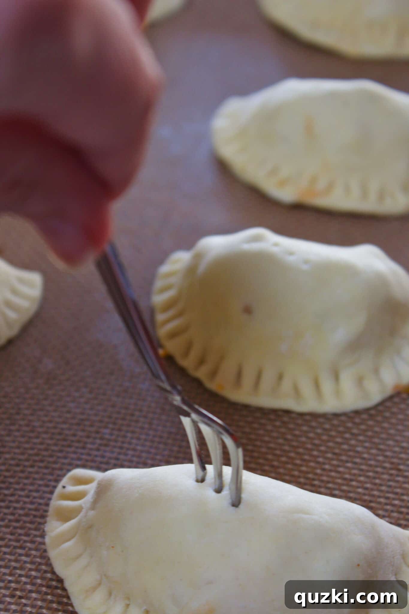 Thanksgiving Leftover Turkey Empanadas: A Delicious Reinvention 12 Empanadas brushed with an egg wash and poked with fork holes, prepped and ready for baking to a golden crisp.