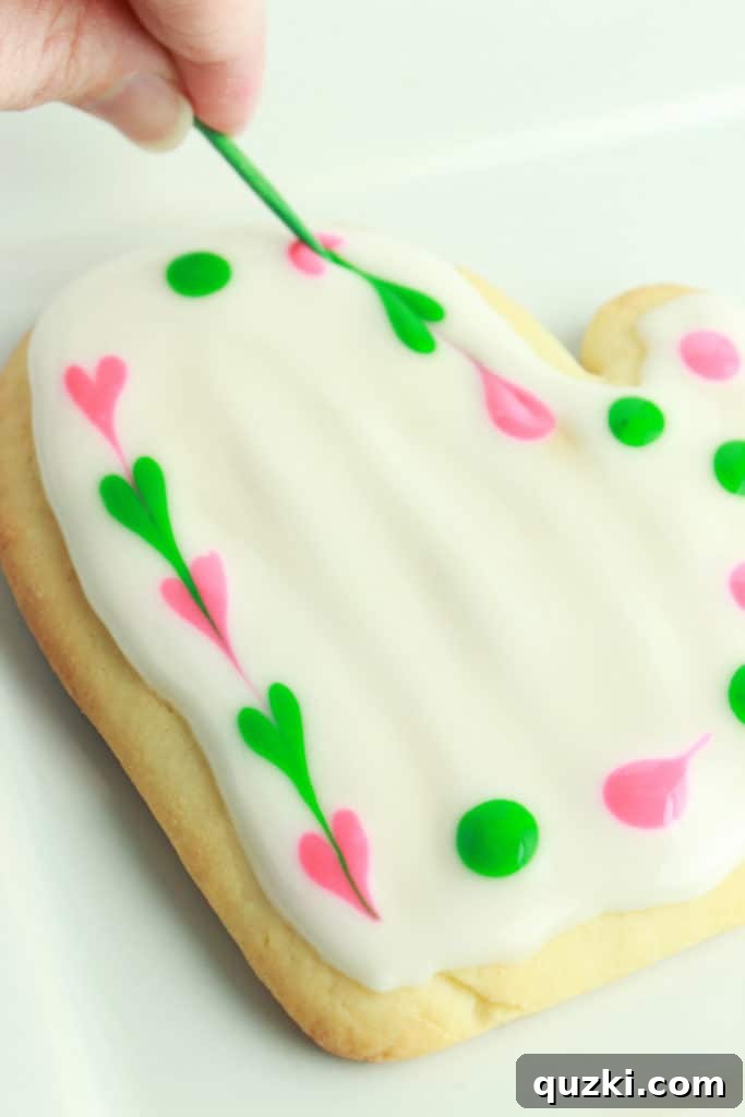 Decorated sugar cookie with a dot and swirl pattern, resembling a flower.