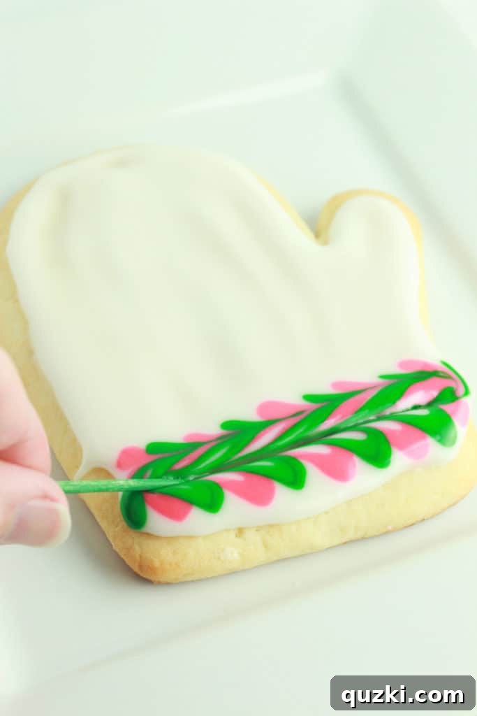 Mitten-shaped sugar cookie with a decorative striped cuff design.