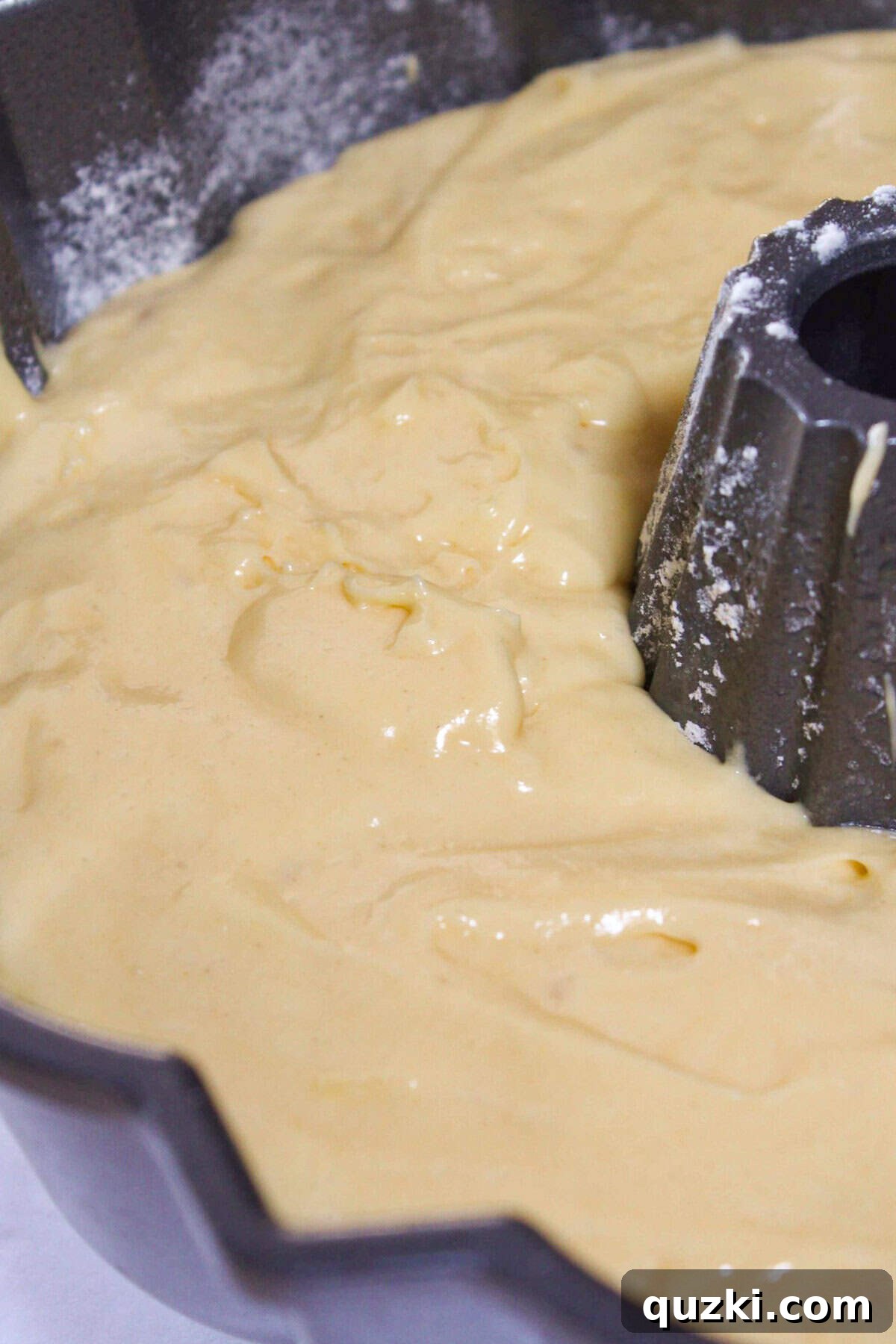 Making the cake batter and pouring part of it into a prepared bundt pan.
