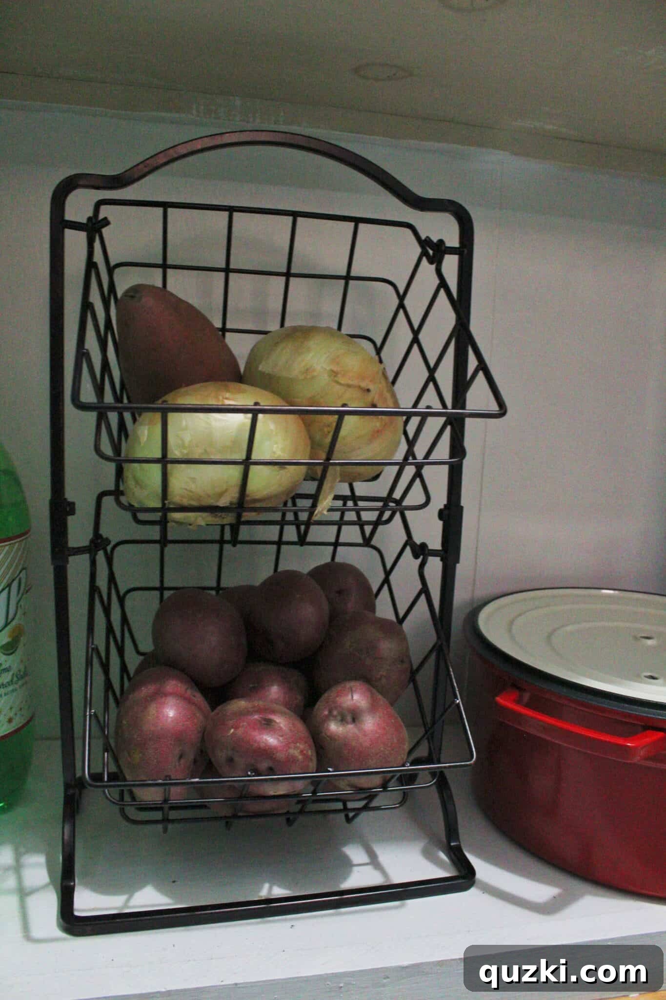 Pantry Organization Game-Changers 12 Countertop fruit storage basket in a pantry, holding potatoes and onions for organized vegetable storage.