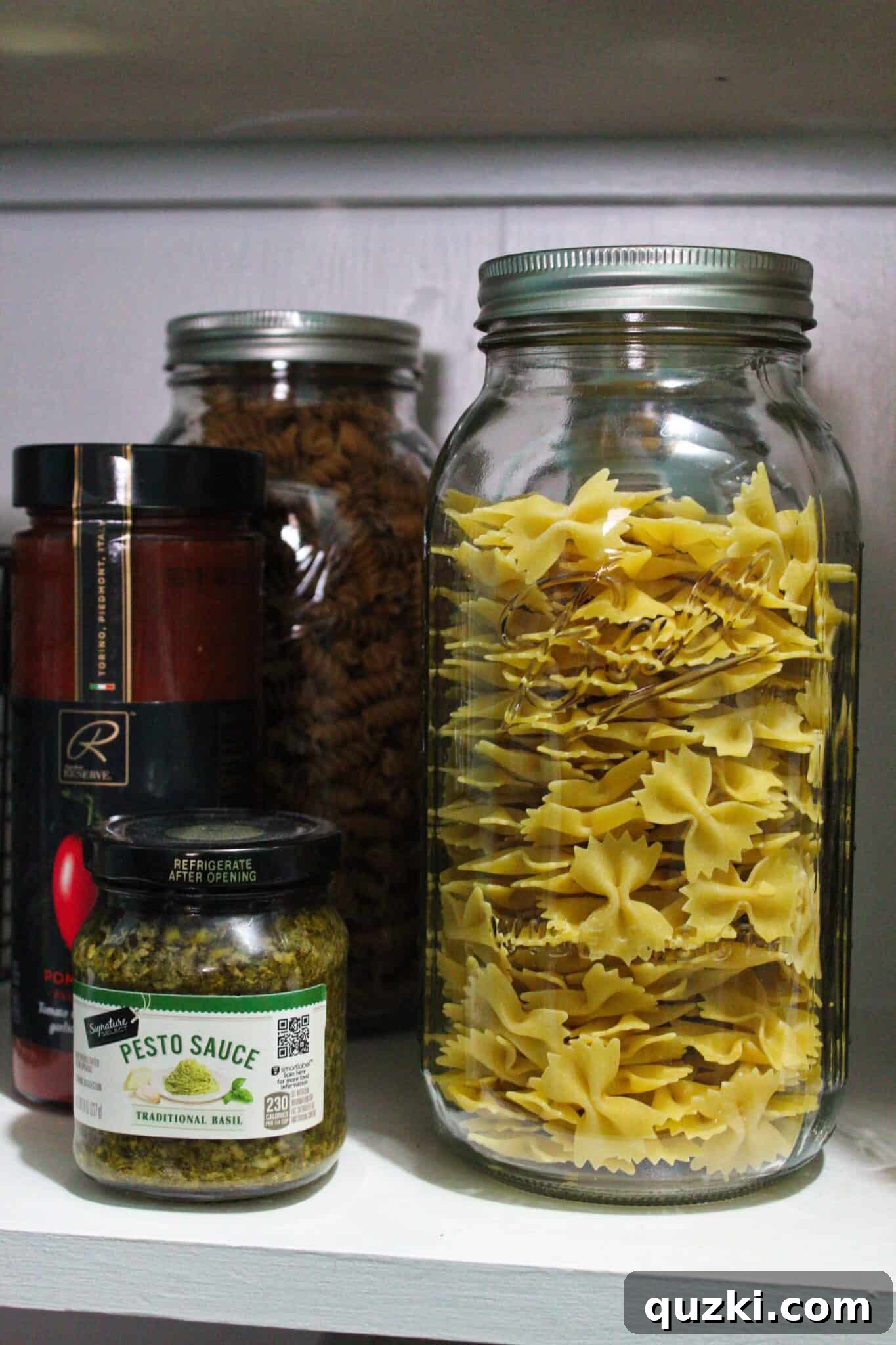 Pantry Organization Game-Changers 9 Half-gallon Mason jars filled with various dry goods in a pantry, showcasing clear and aesthetic storage.