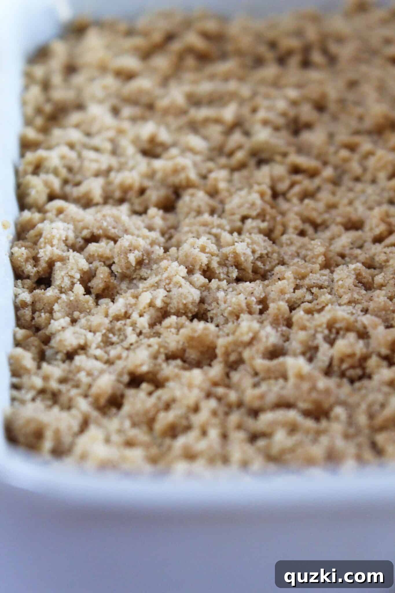 Decadent Banana Chocolate Chip Crumb Cake 9 Applying crumb topping over the Banana Chocolate Chip Crumb Cake batter