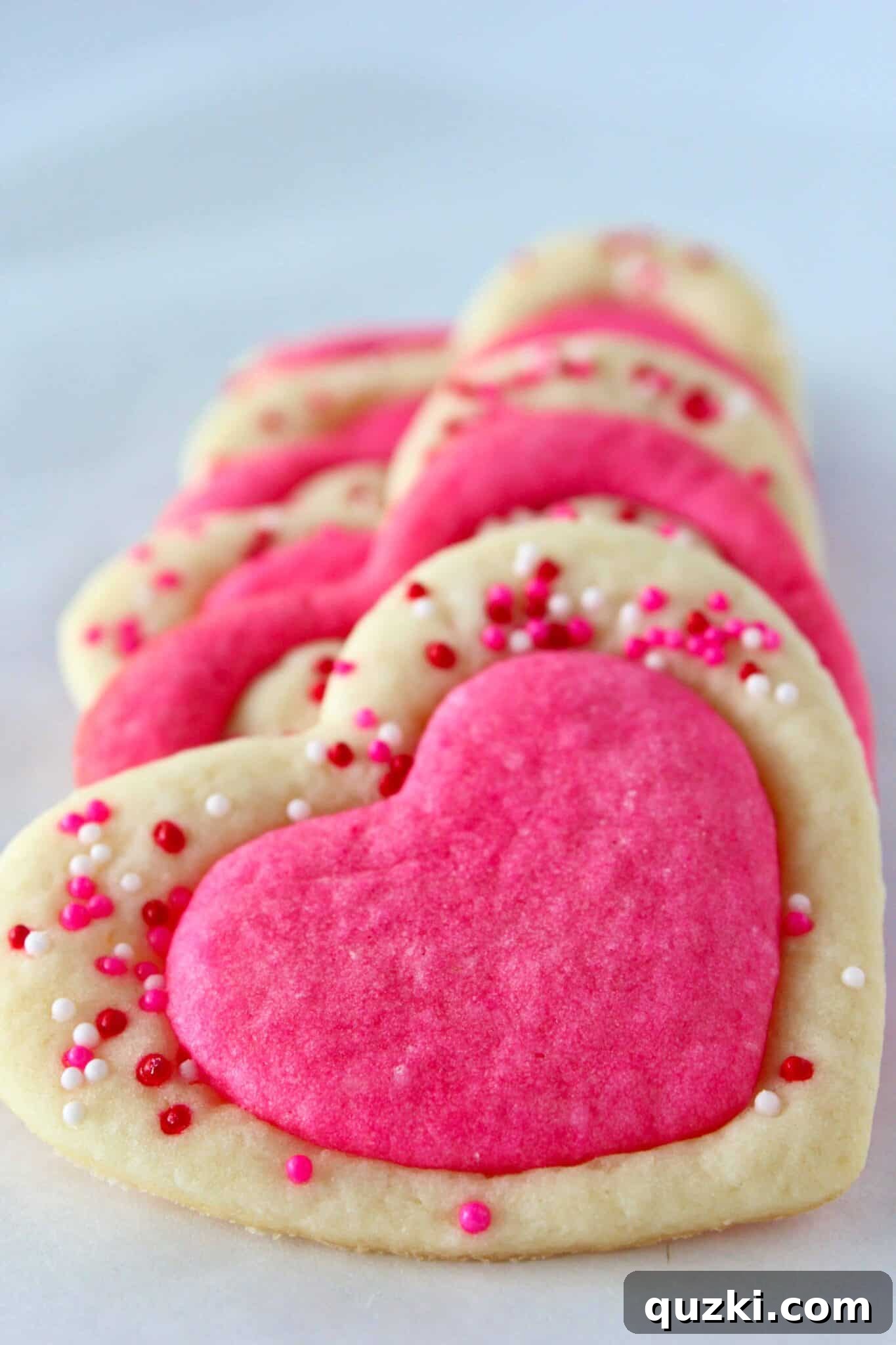 A close-up of a plate filled with beautiful two-tone Valentine's Day sugar cookies, ready to be enjoyed