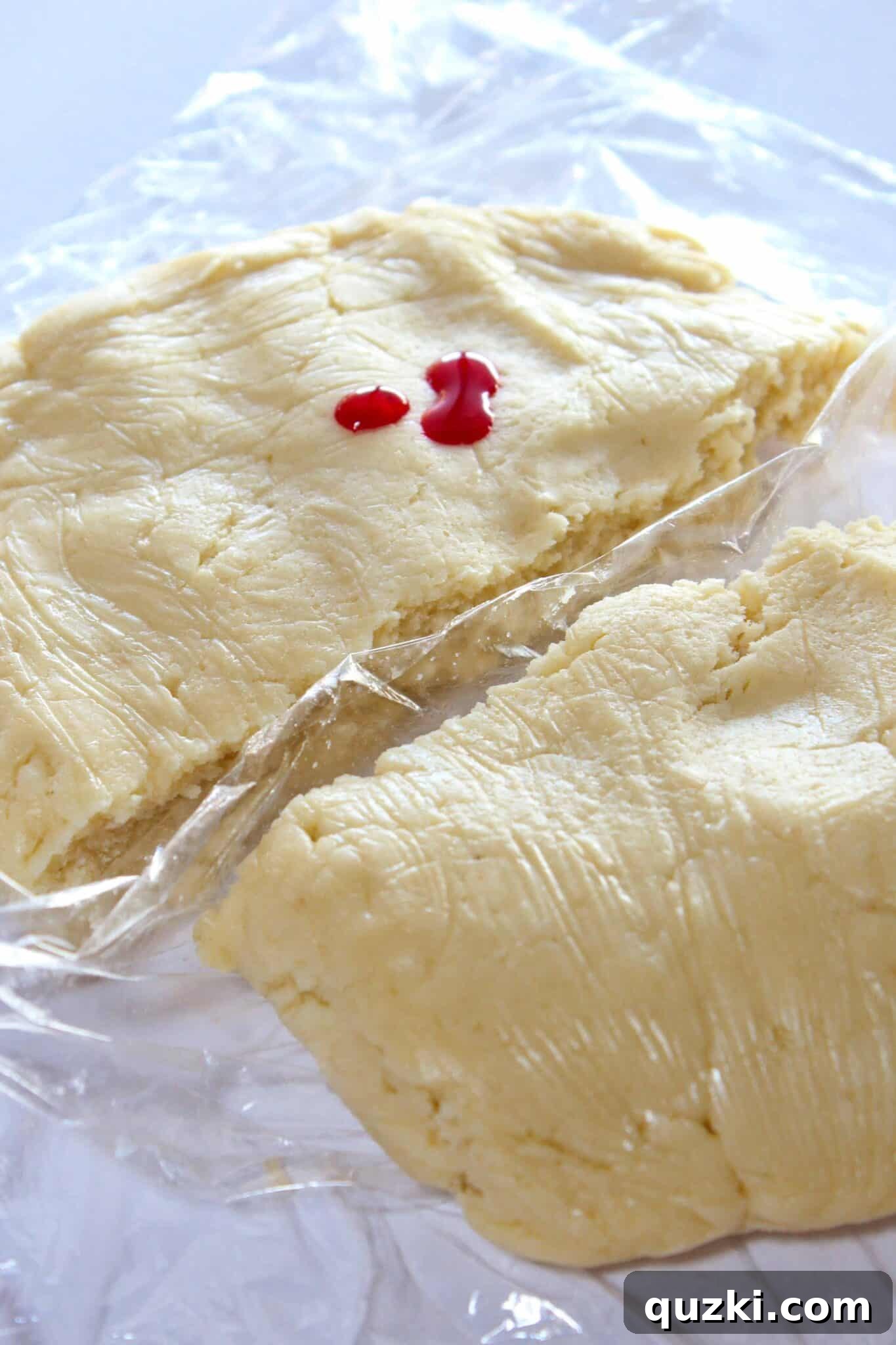 Adding gel food coloring to cream cheese sugar cookie dough to create a soft pink hue