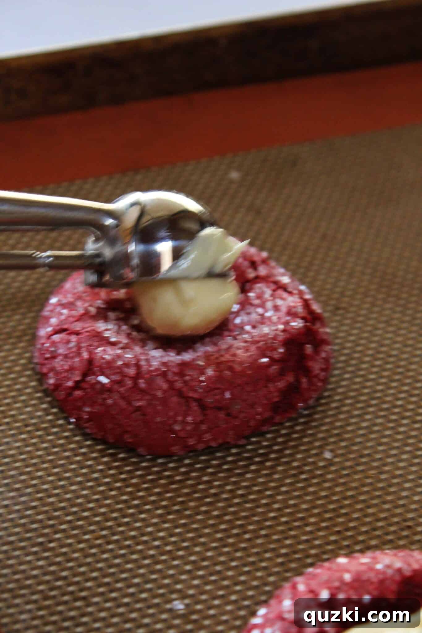 Indulgent Valentines Red Velvet Cheesecake Cookies Cake Mix Magic 11 Cheesecake filling being carefully spooned into the indentations of red velvet cookies