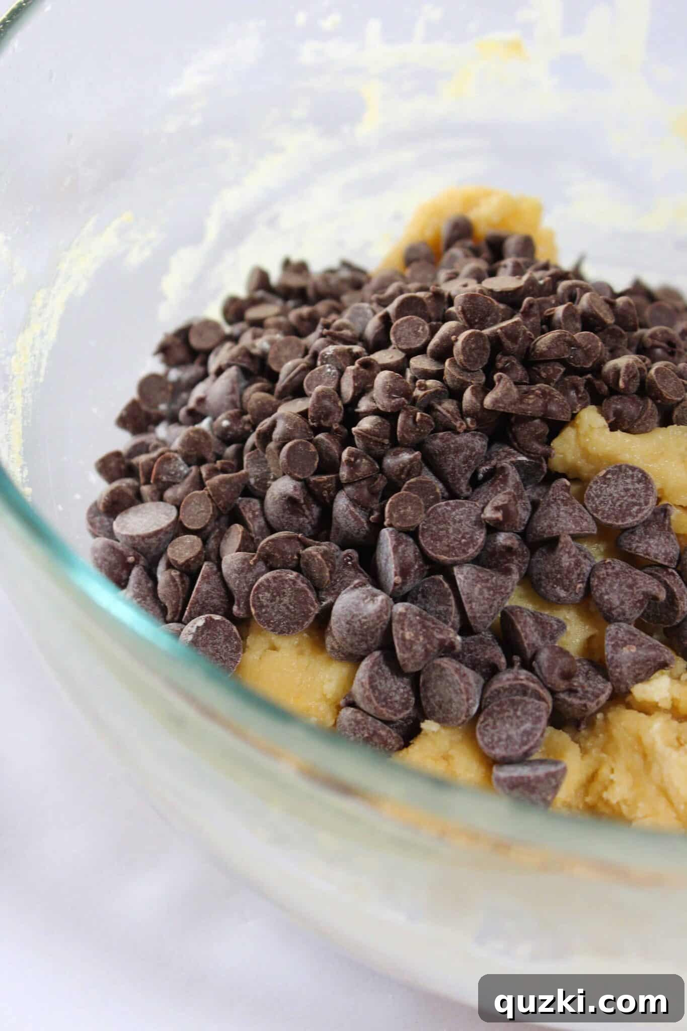 Melt-in-Your-Mouth Soft Chocolate Chip Delights 10 Chocolate chips being added to the thick cookie dough.