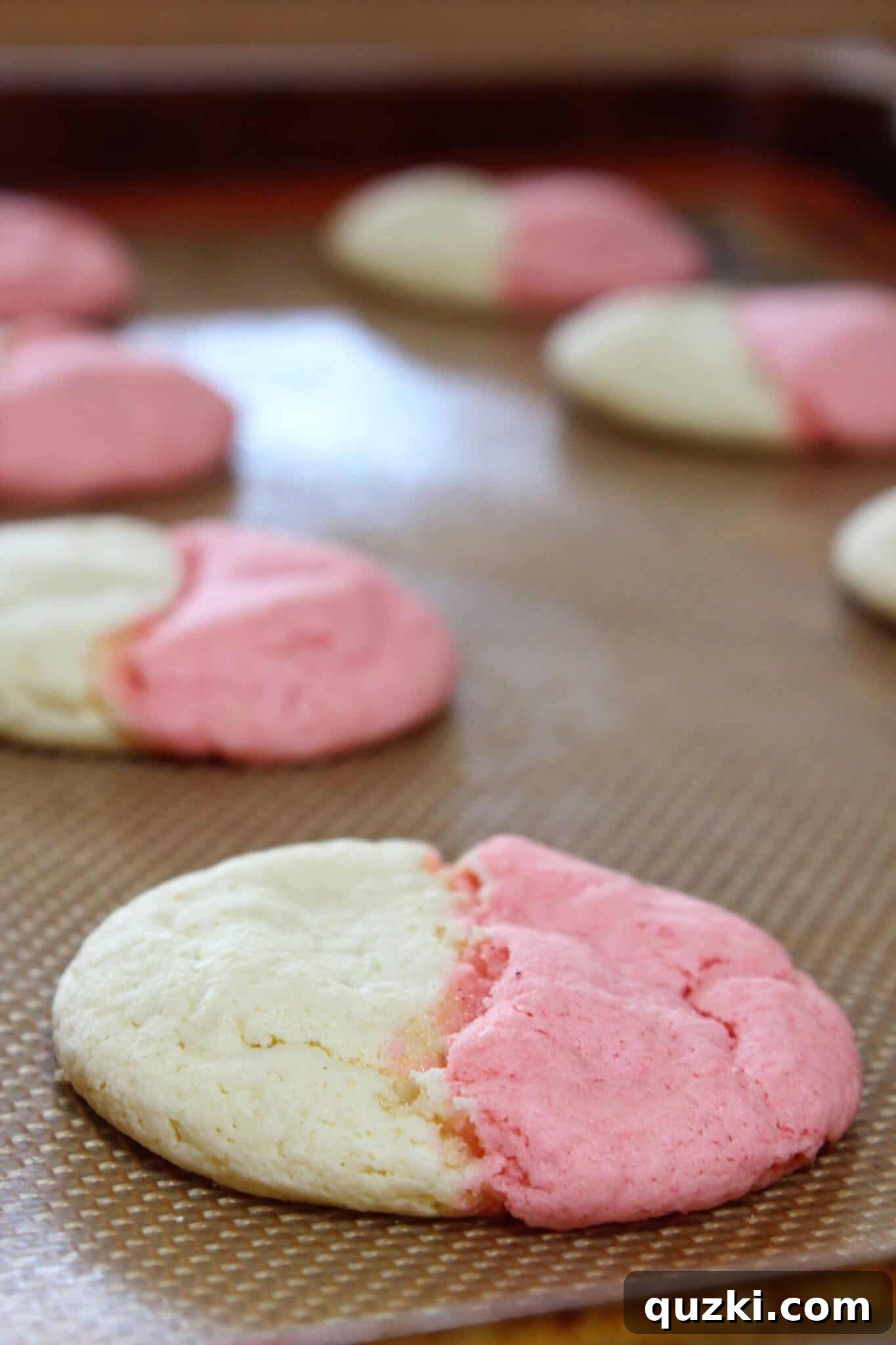 Freshly baked Neapolitan Cookies cooling on a baking sheet, showcasing their fluffy texture and vibrant colors
