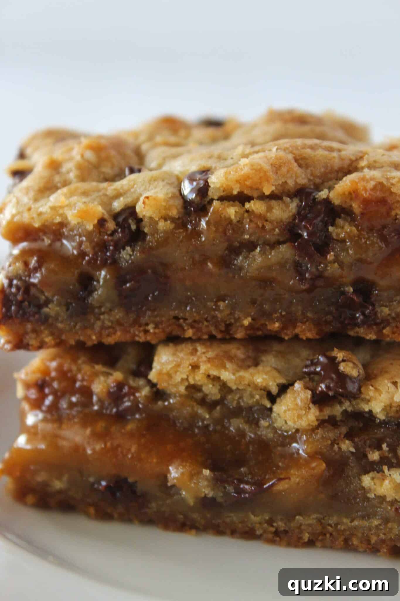 Salted Caramel Chocolate Chip Cookie Bars 2 Stacked Salted Caramel Chocolate Chip Cookie Bars showing gooey caramel center, perfect for a decadent dessert.