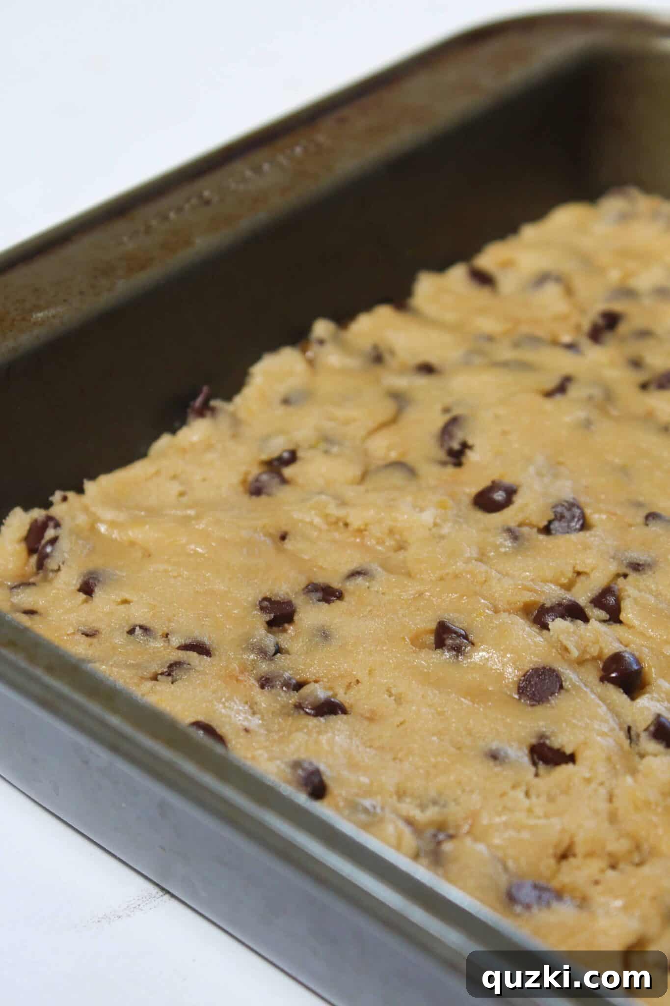 Salted Caramel Chocolate Chip Cookie Bars 11 Adding the final layer of cookie dough on top of the salted caramel.