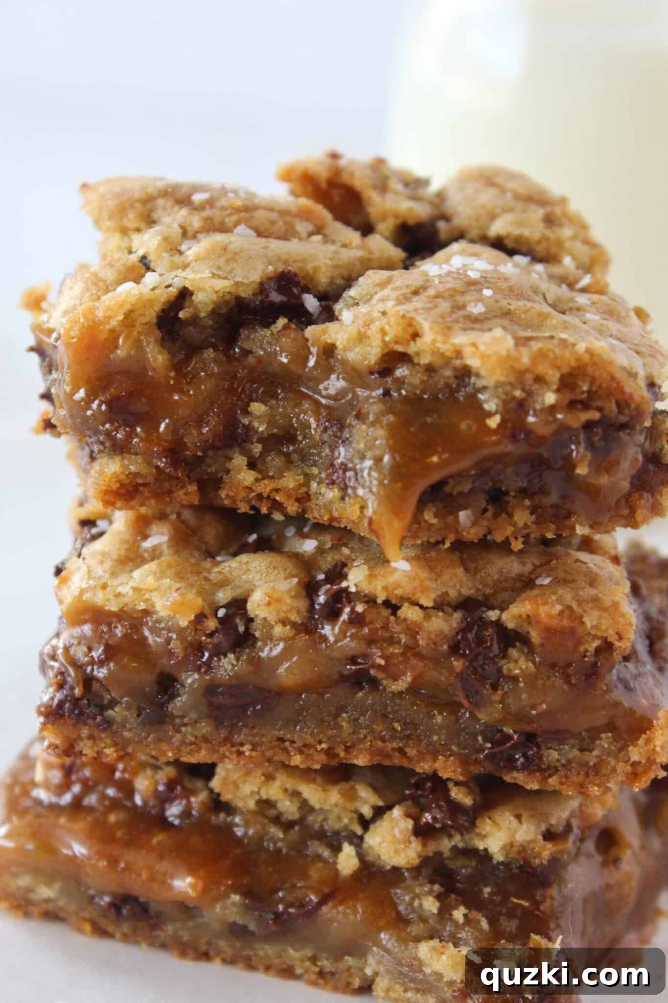 Salted Caramel Chocolate Chip Cookie Bars 13 A Salted Caramel Chocolate Chip Cookie Bar with a bite taken, revealing the soft cookie and gooey caramel.