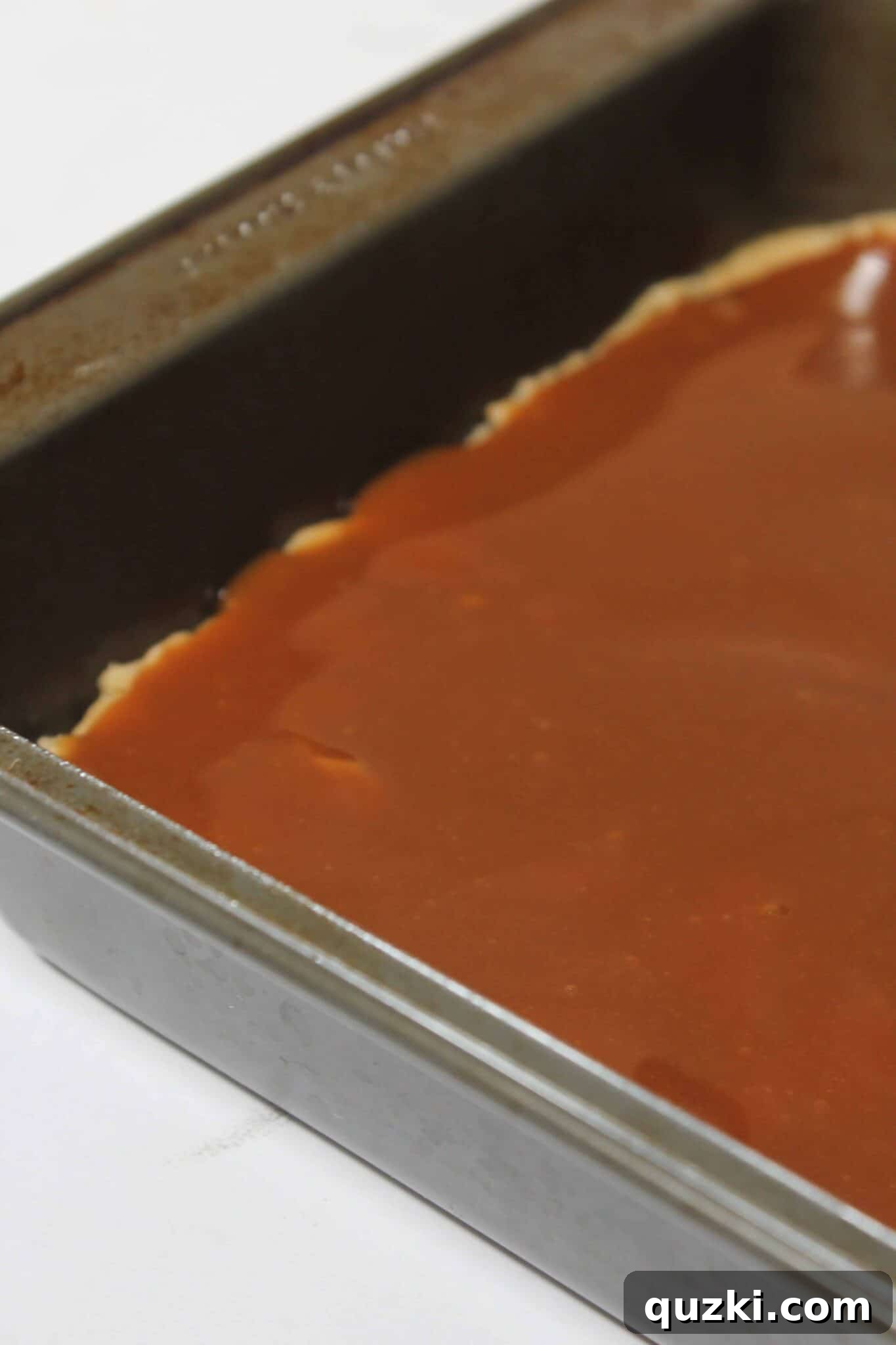 Salted Caramel Chocolate Chip Cookie Bars 9 Spreading salted caramel sauce over the base layer of chocolate chip cookie dough.