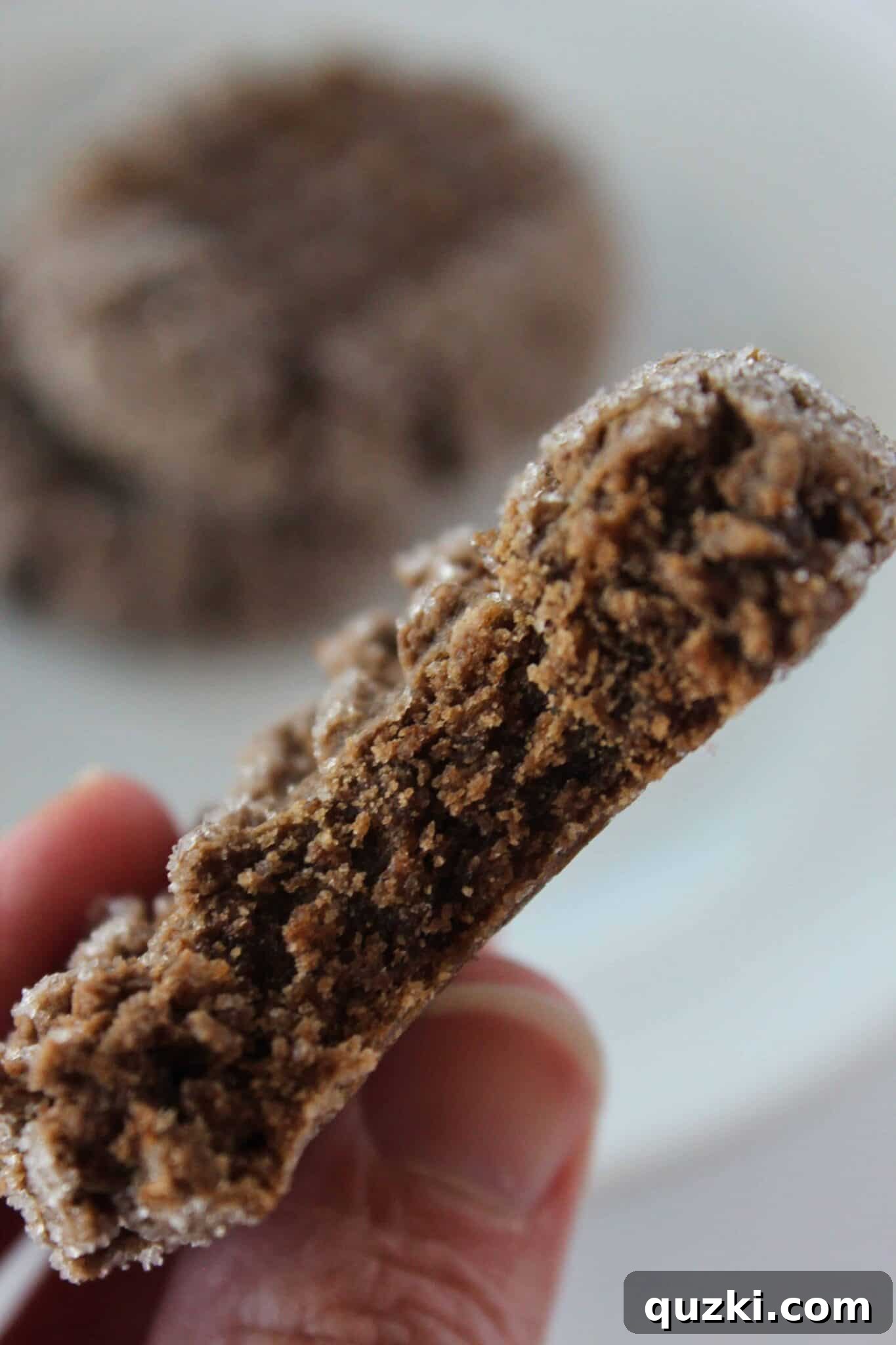 A delicious Chocolate Cake Mix Cookie with Peanut Butter swirl, with a bite taken from it, showcasing its soft texture.