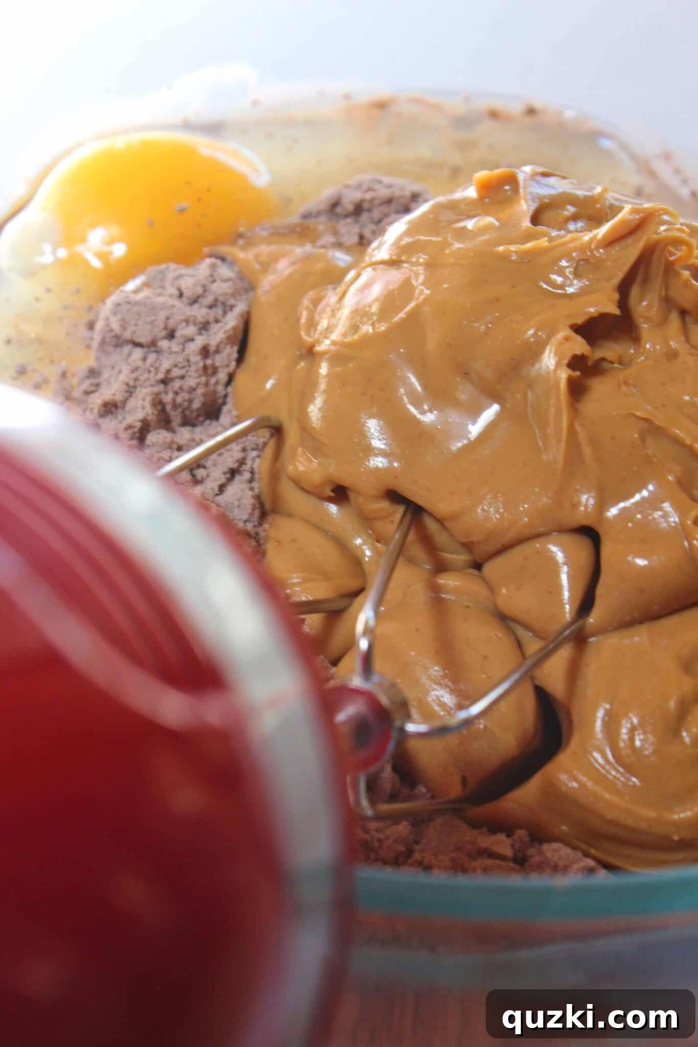Mixing the chocolate cake mix, creamy peanut butter, melted butter, and eggs to form the initial cookie dough.