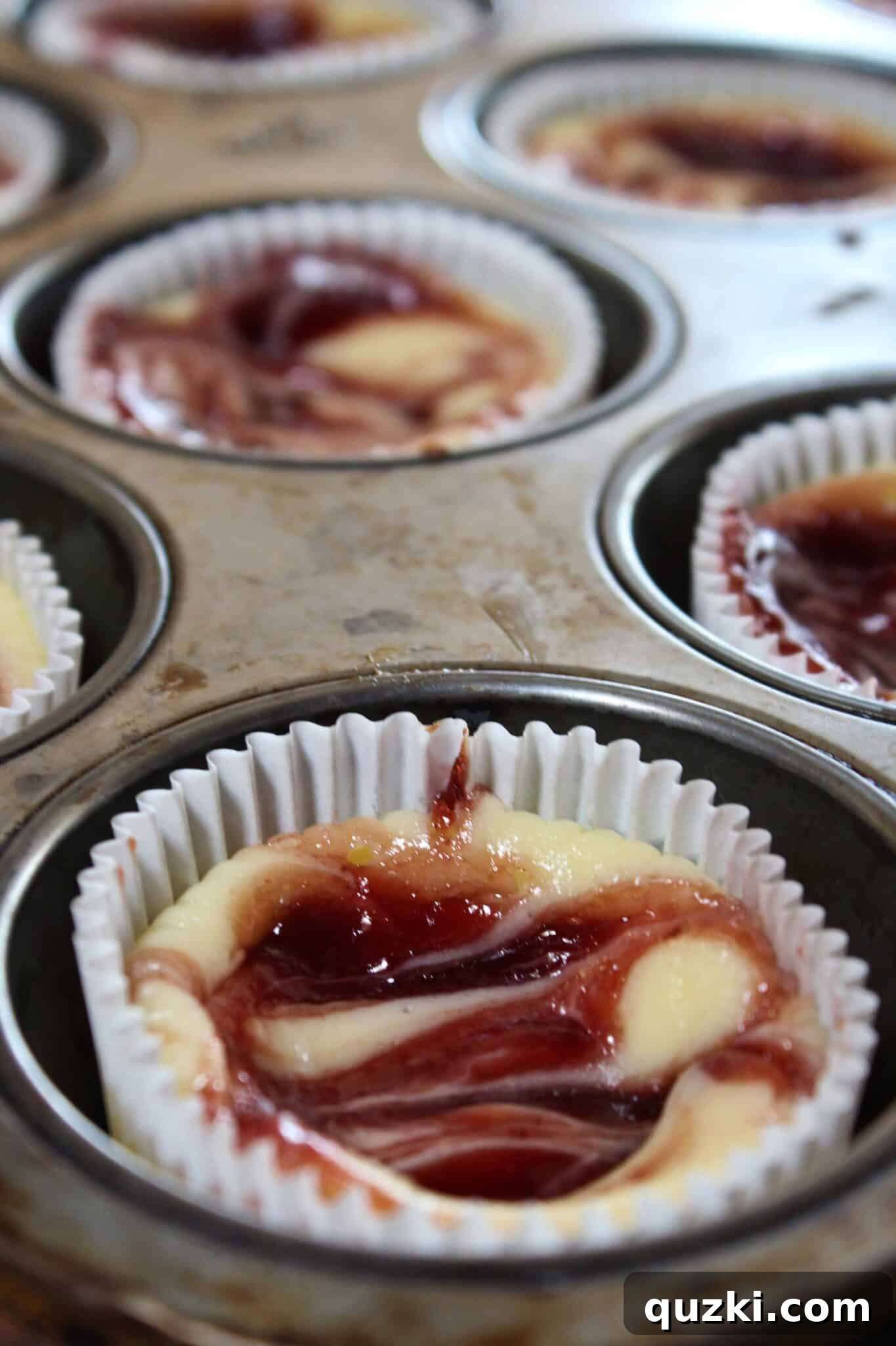 Decadent Mini Raspberry Cheesecake Cups 14 A side view of a Mini Raspberry Cheesecake, showing the firm crust and creamy filling.