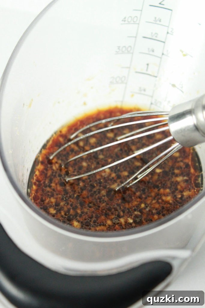 Mixing the Korean marinade ingredients: brown sugar, soy sauce, minced garlic, sesame oil, and rice wine vinegar in a bowl.