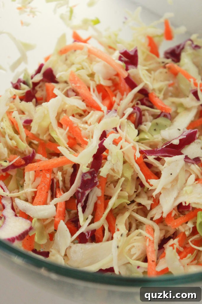 Freshly prepared zesty coleslaw in a bowl, ready to be added as a topping for Korean pork tacos.