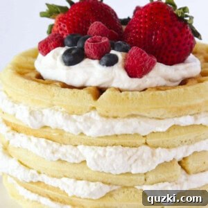 A waffle cake with homemade whipped cream and fresh berries.