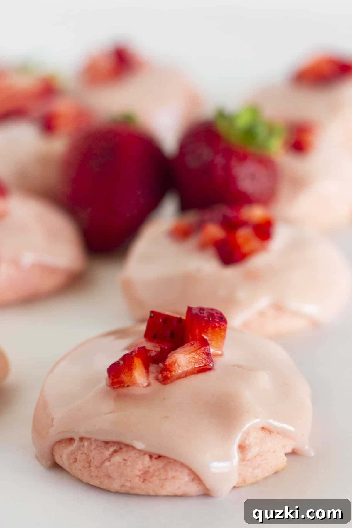 Pillowy Strawberry Cake Cookies 2 Soft and chewy Strawberry Cake Mix Cookies on a white tray, garnished with fresh berries.