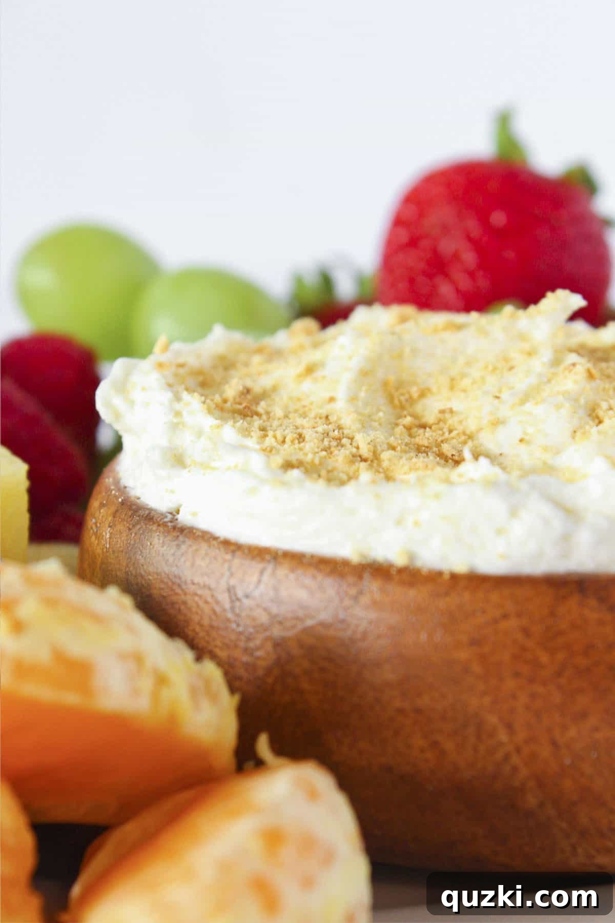No-Bake Cheesecake Dip for Fruit 2 Cheesecake dip for fruit in a bowl and surrounded by fresh fruit.