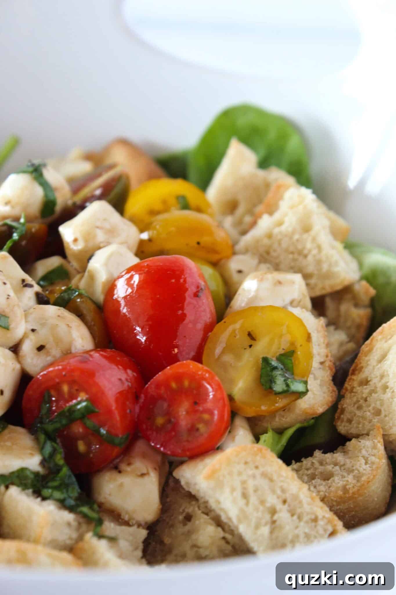 Quick Bruschetta Salad 12 A large serving bowl filled with a Quick Summer Salad, featuring the vibrant bruschetta topping placed over crisp mixed greens and surrounded by croutons.