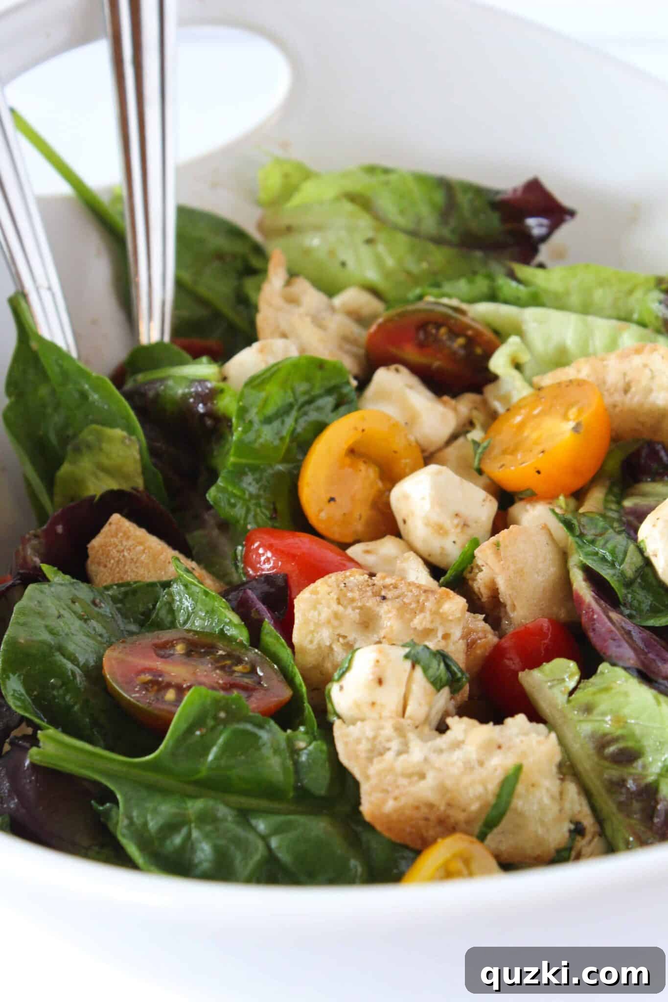 Quick Bruschetta Salad 13 A generous serving of Bruschetta Salad presented in a pristine white bowl, adorned with fresh garlic croutons and a garnish of basil.