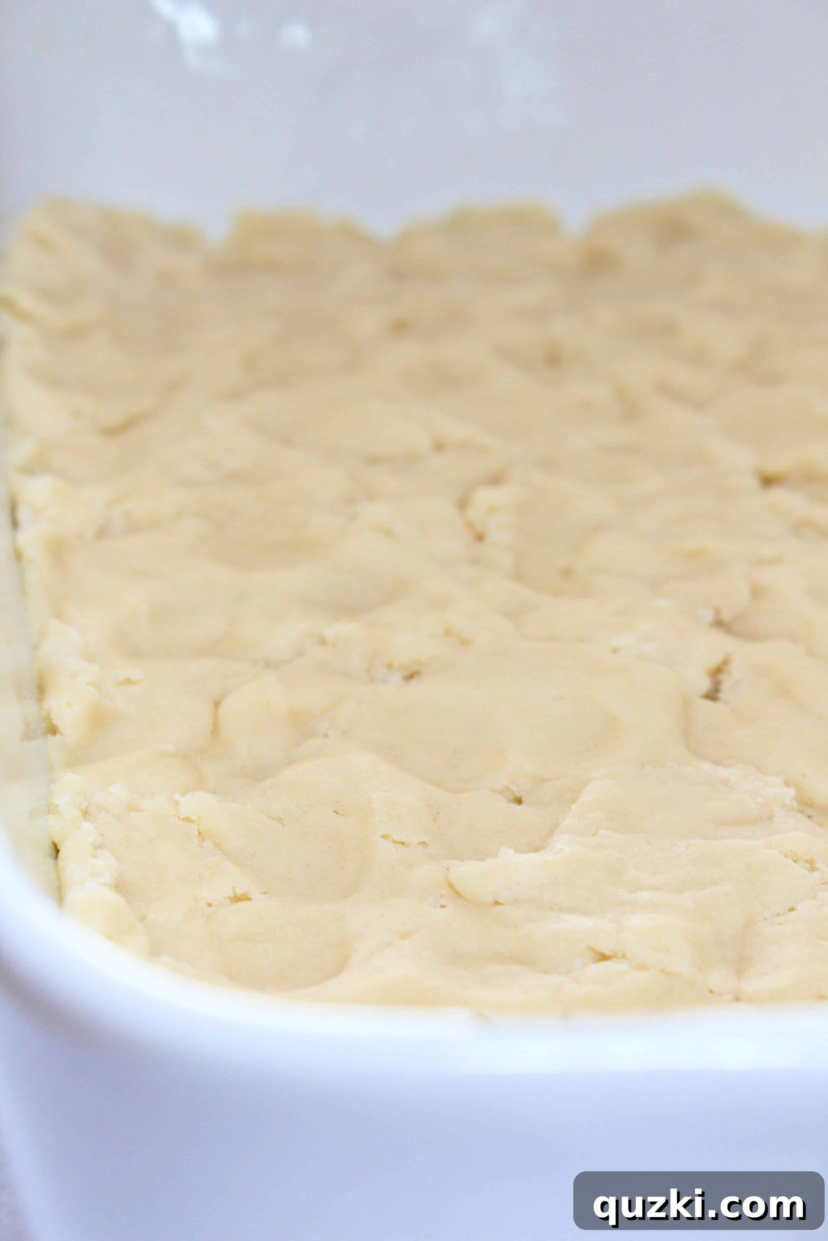 Festive Fourth of July Cookie Bars 4 Pressing 2/3 of the cream cheese sugar cookie dough into a 9x13 inch pan to form the base crust for the 4th of July cookie bars.