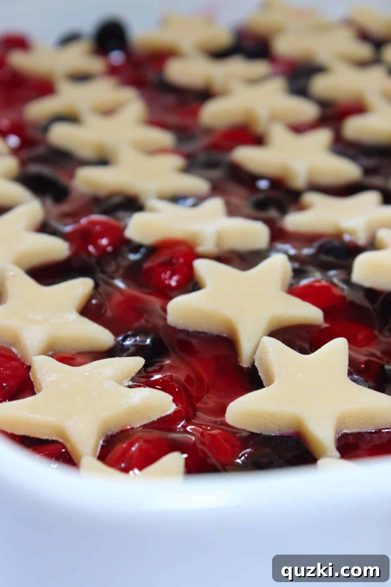 Festive Fourth of July Cookie Bars 9 Arranging small star cookie cutouts on top of the cherry and blueberry filling for a star-spangled 4th of July cookie bar design.