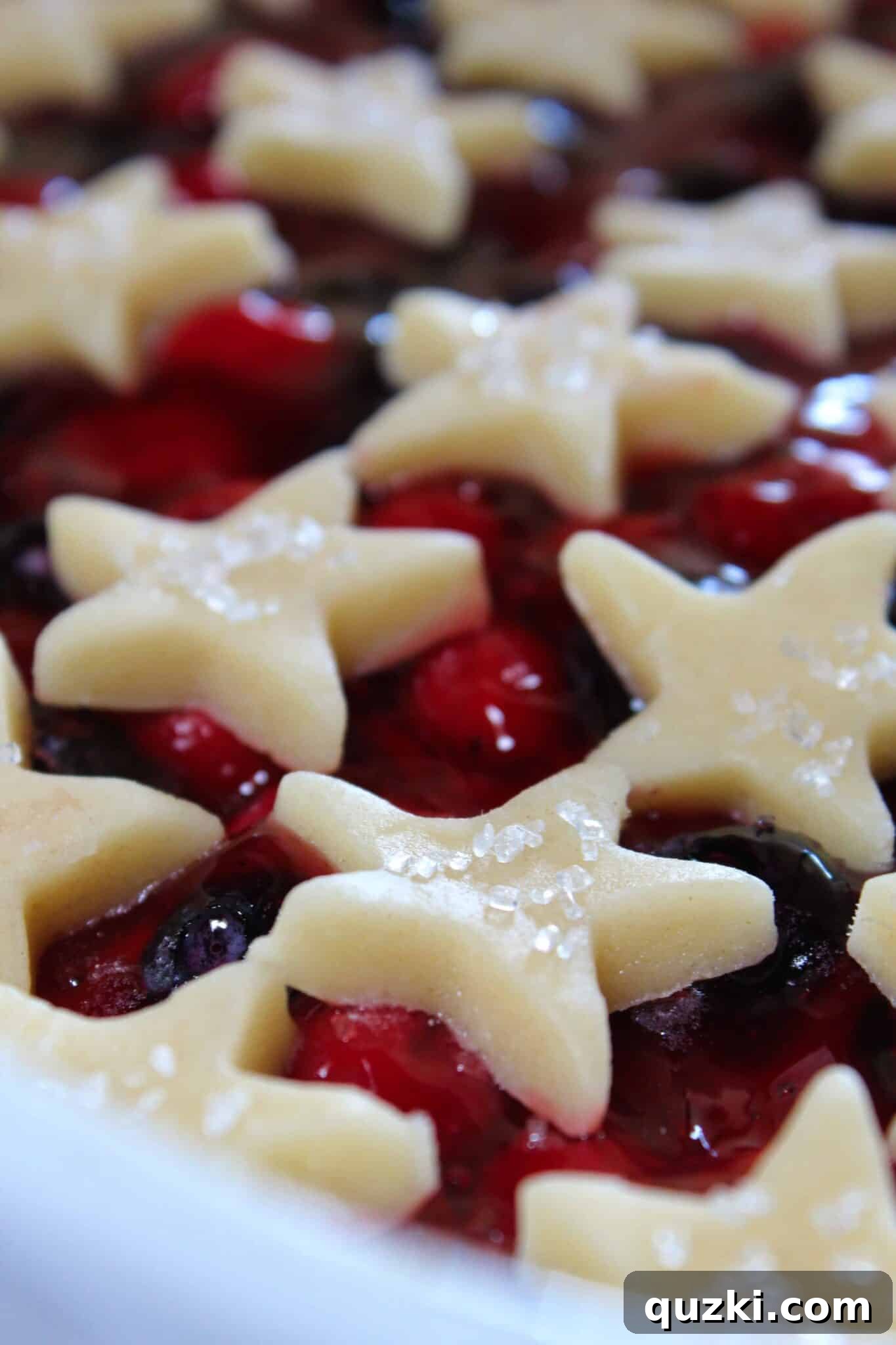Festive Fourth of July Cookie Bars 10 Sprinkling sanding sugar over the star cookie cutouts before the final bake, adding sparkle and texture to the 4th of July cookie bars.