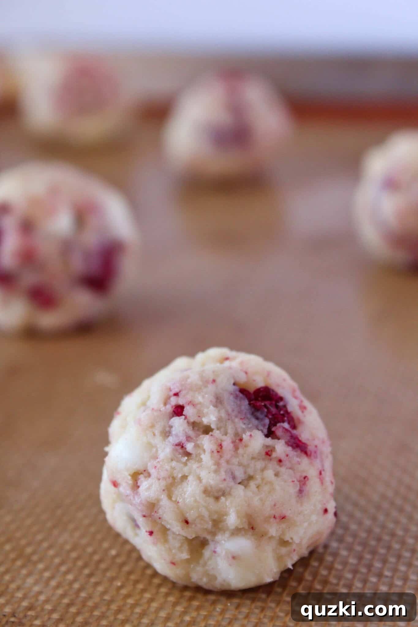 Subway's Iconic Raspberry Cheesecake Cookies Make Them At Home 8 Scooping cookie dough onto a parchment-lined baking sheet for Copycat Subway Raspberry Cheesecake Cookies.