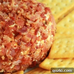 A bacon coated jalapeño popper cheese ball with butter crackers around it, presented on a simple serving plate.