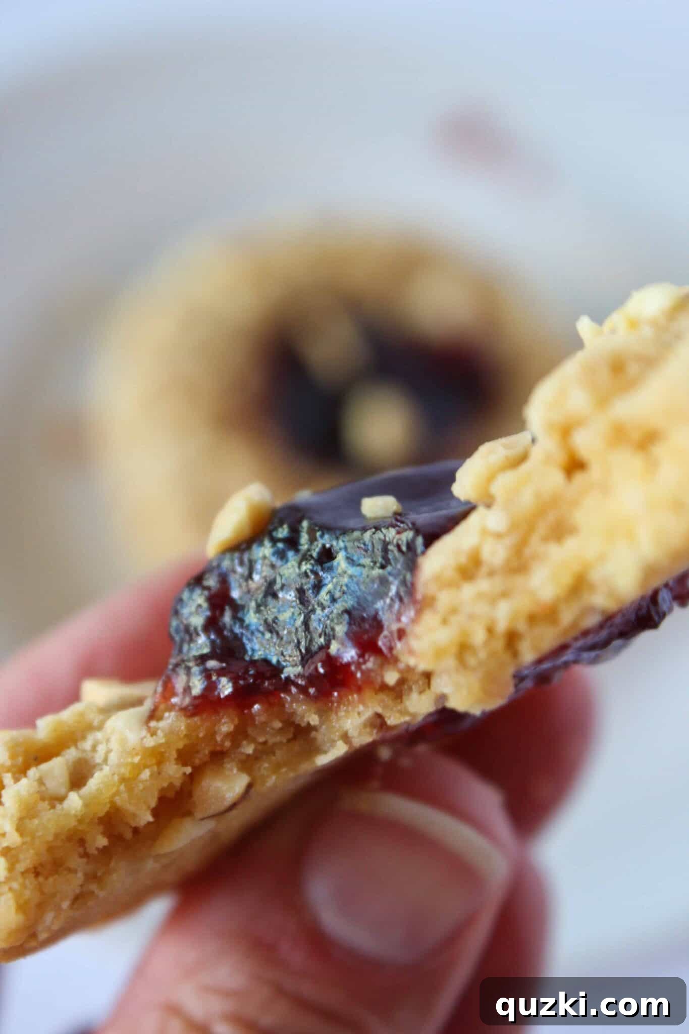 A delicious PB&J Cookie with a bite taken from it, revealing the jam center.