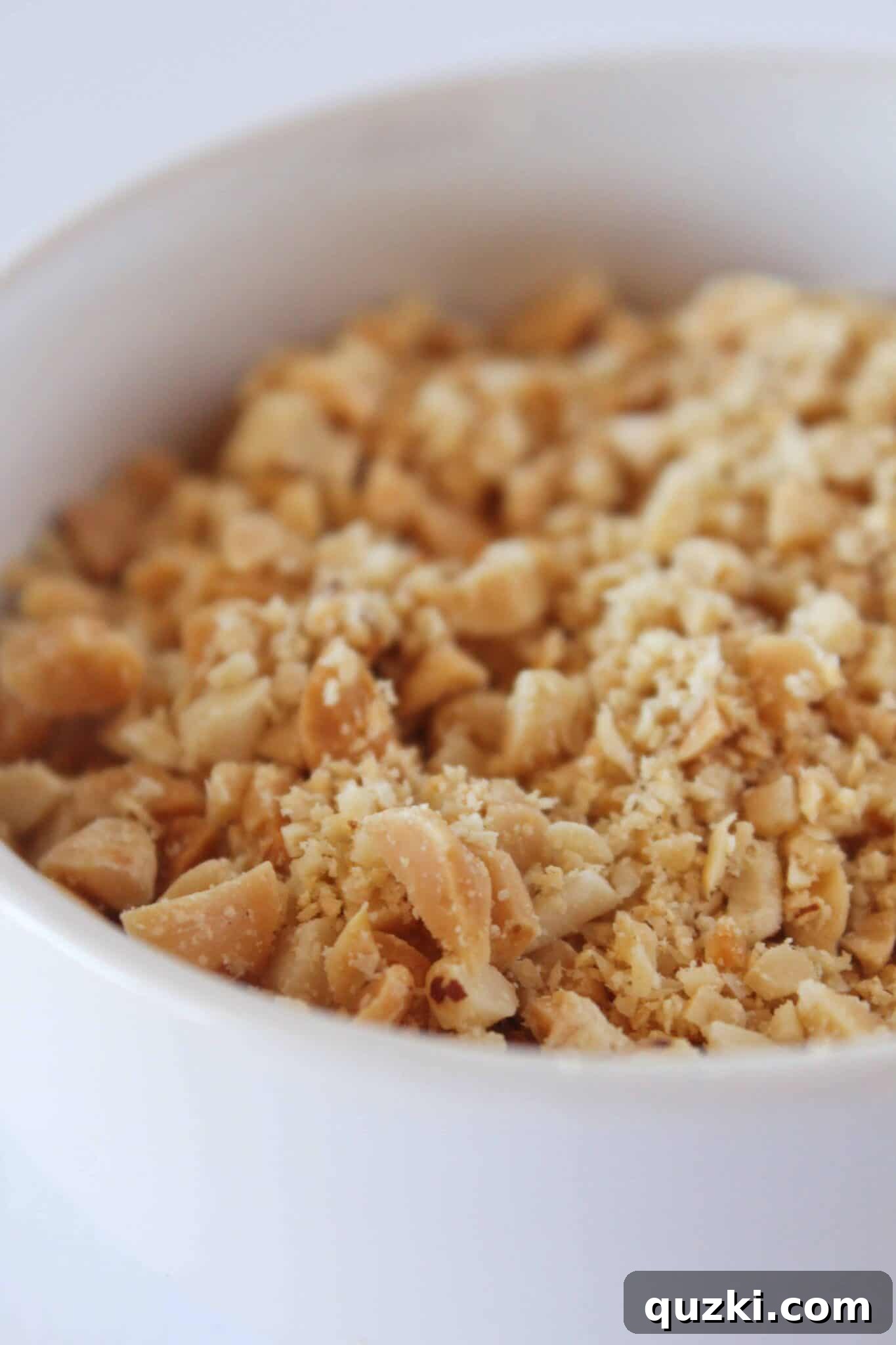 Bowl of finely chopped peanuts ready for coating cookies.