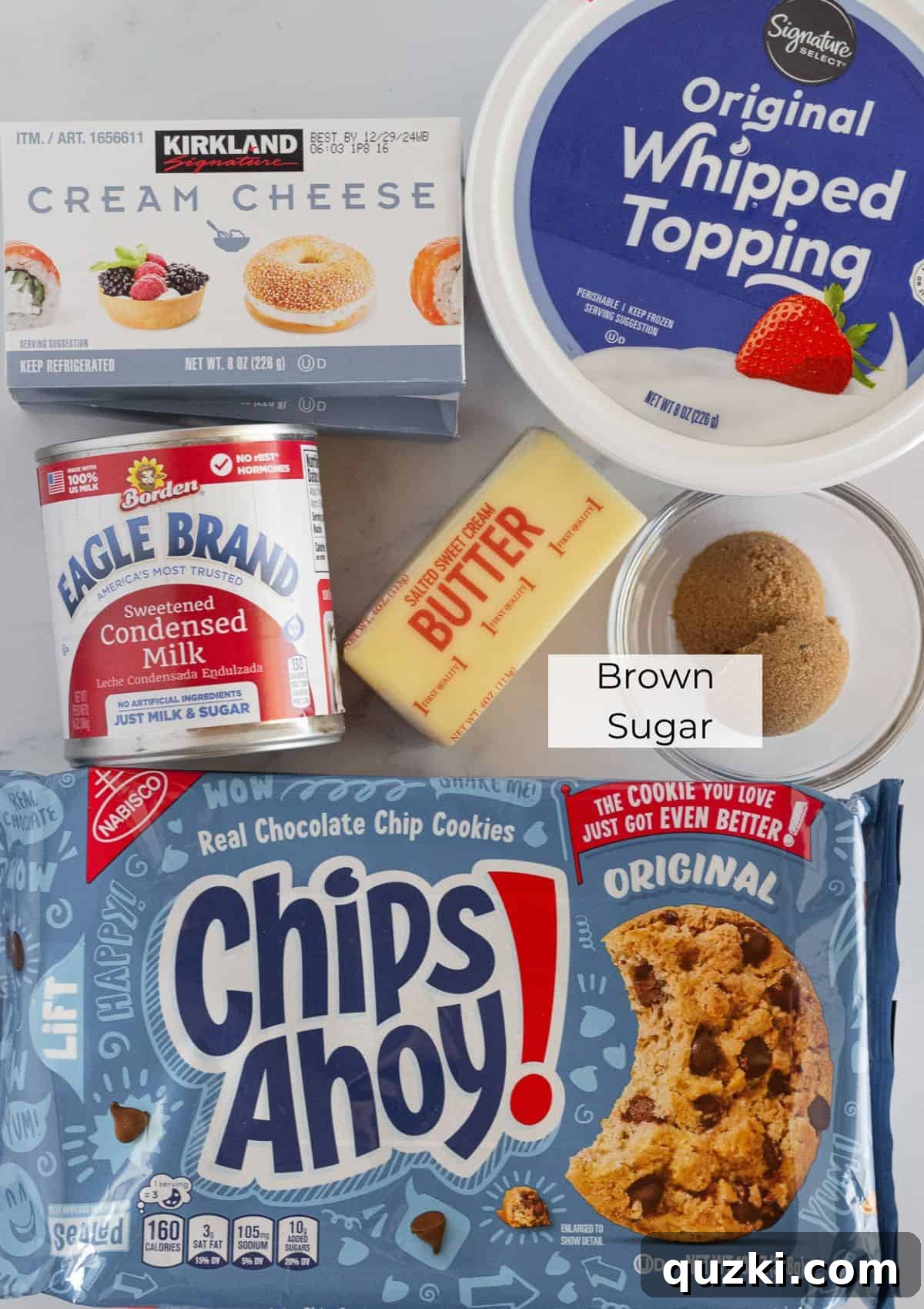 The essential ingredients neatly laid out on a counter, ready to be transformed into a delicious chocolate chip cookie cheesecake.